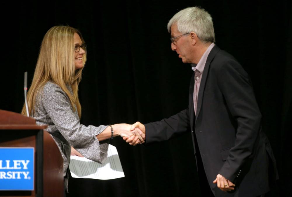Lisa Perhamus shakes hands with Jeff Kelly Lowenstein, the fourth endowed professor of civil discourse